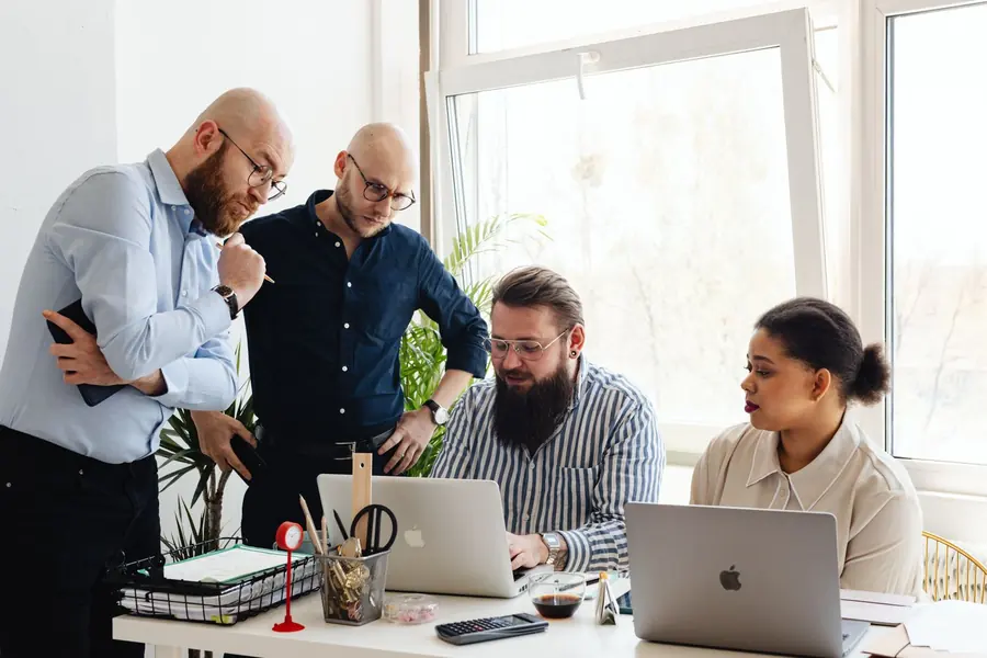 Equipe reunida analisando dados em notebooks