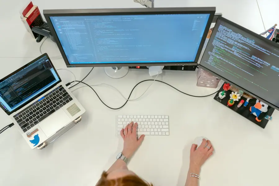 Estação de trabalho com monitores exibindo código
